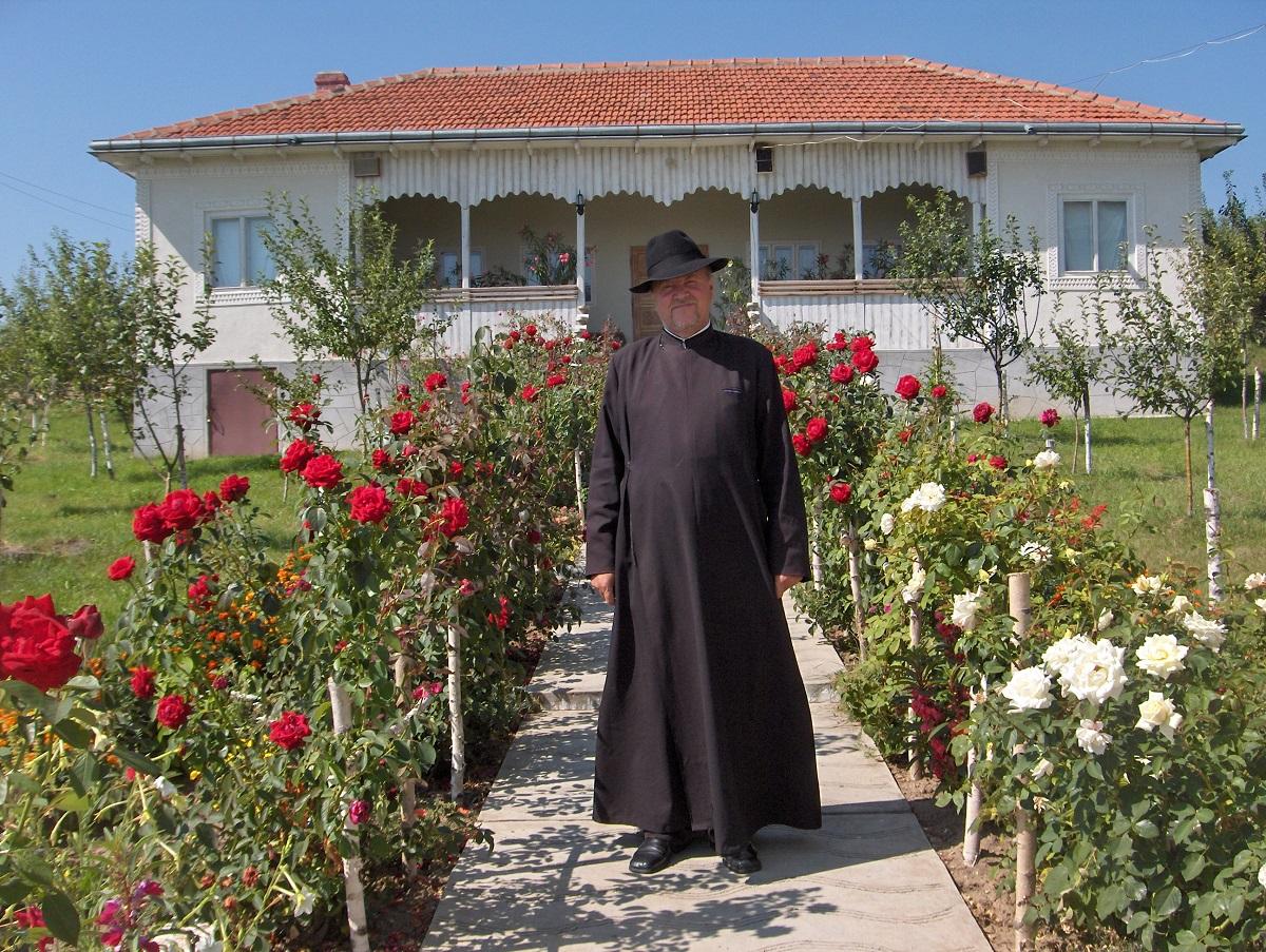 Preotul paroh în fața casei
